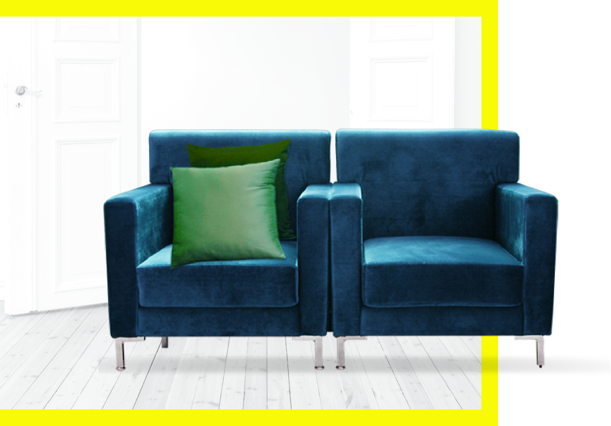 A matched set of two teal armchairs with a pair of green accent pillows.